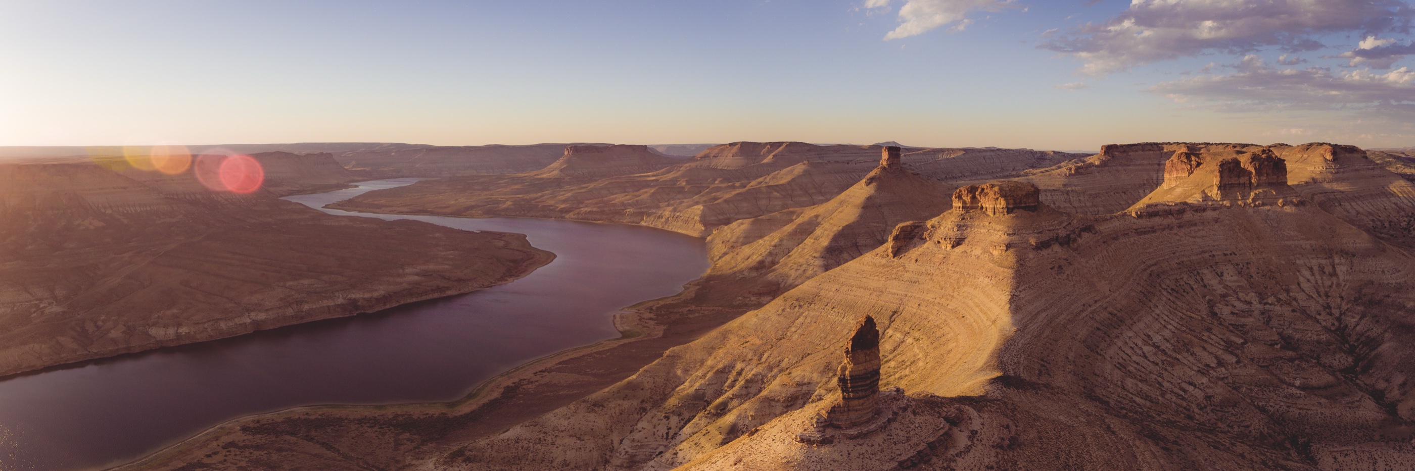 Aerial view of a river winding through Wyoming canyon country at golden hour